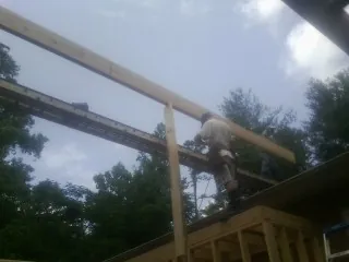 Carpenter setting a ridge beam over a new addition frame — Ice Dam Removal by Roofing Brothers in North Branford