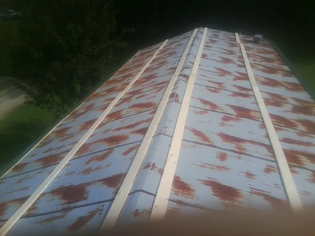 Rusted metal roof panels with new wood purlins before replacement — Storm Damage Roof Repair in North Branford by Roofing Brothers