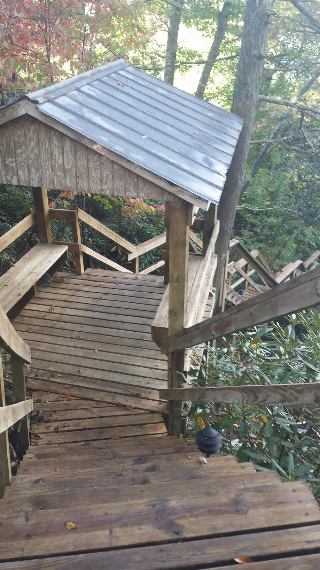 Metal roofed shelter over wooden steps on a wooded walkway — Skylight Repair & Installation work by our crew in North Branford